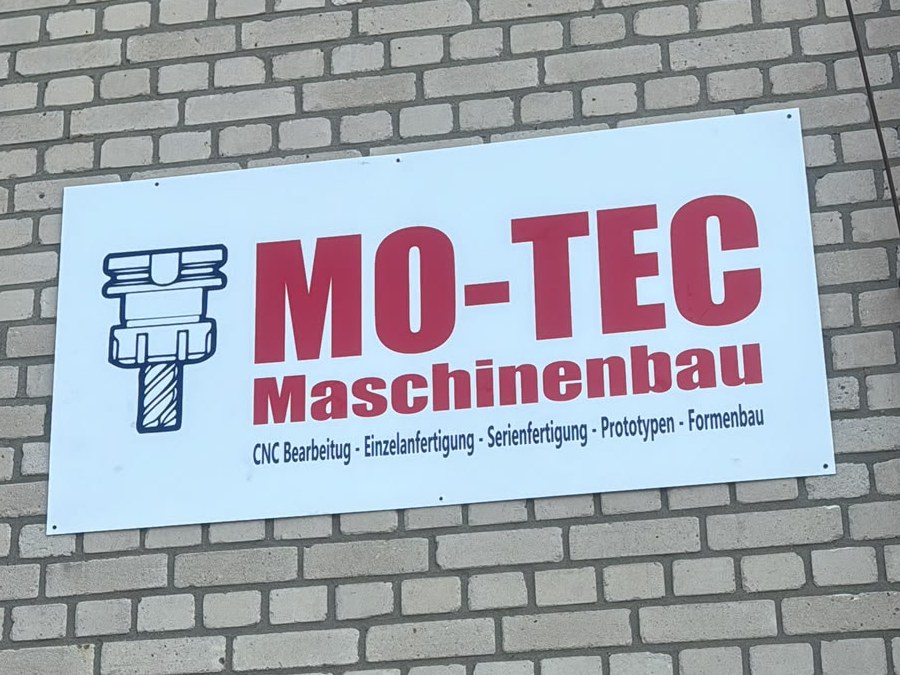 Firmenschild MO-TEC Maschinenbau an der Klinkerfassade des Betriebs