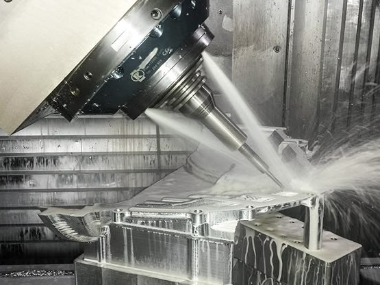 Fünfachsig geschwenkter Fräskopf bearbeitet ein Aluminiumbauteil unter Kühlmittel