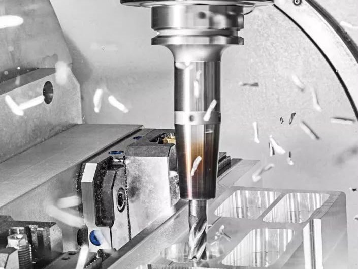 Schaftfräser zerspant eine Aluminiumtasche, Späne im Flug